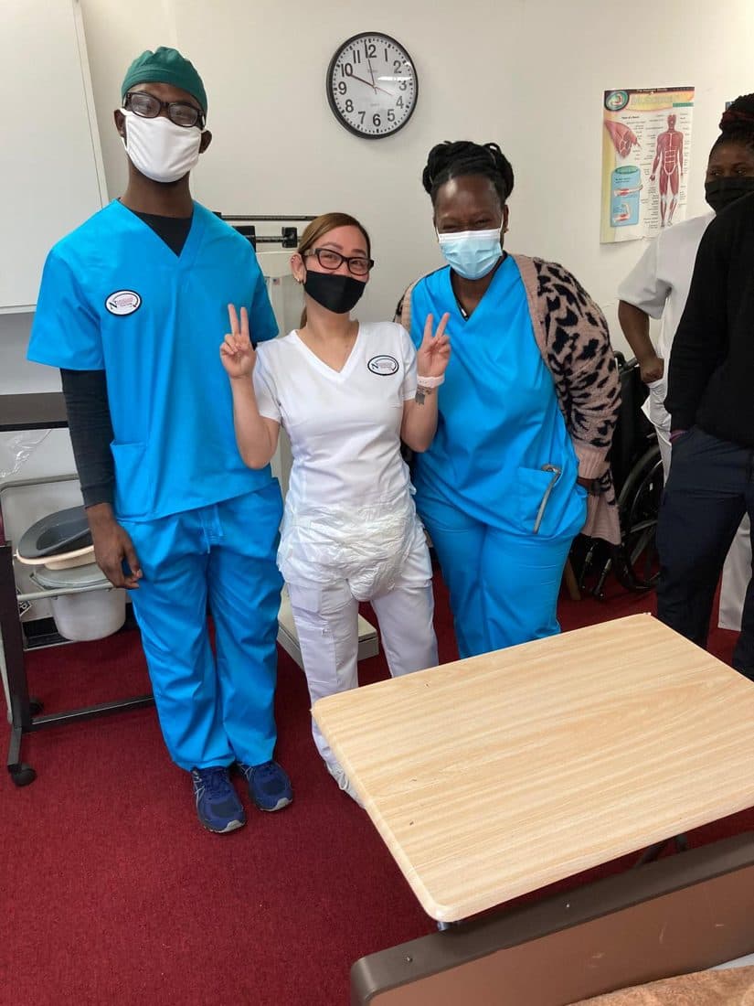 Students practicing patient care skills in the training lab